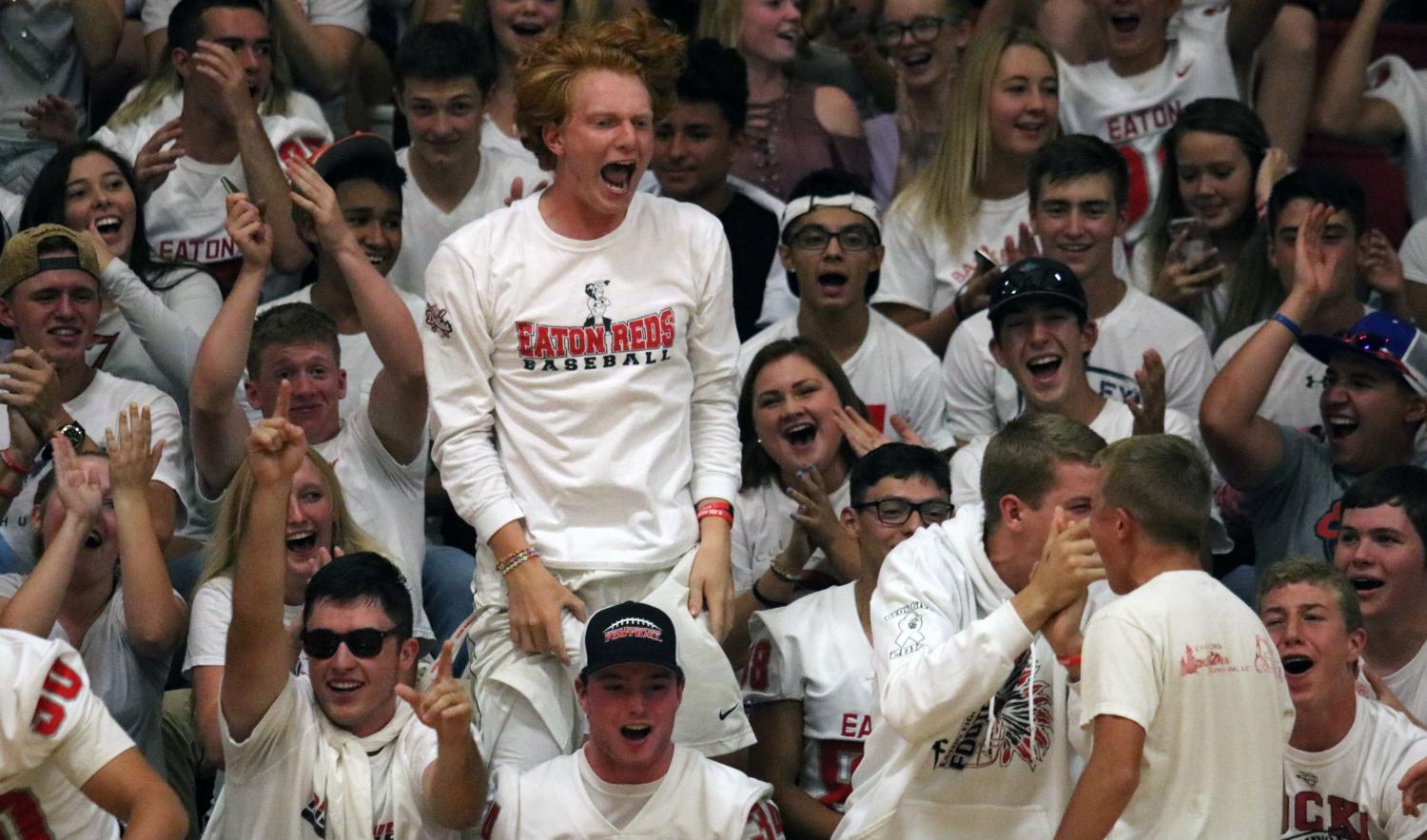 With all students dressed for a white-out, CJ Baskowski (18) jumps out of his seat to celebrate a Ma