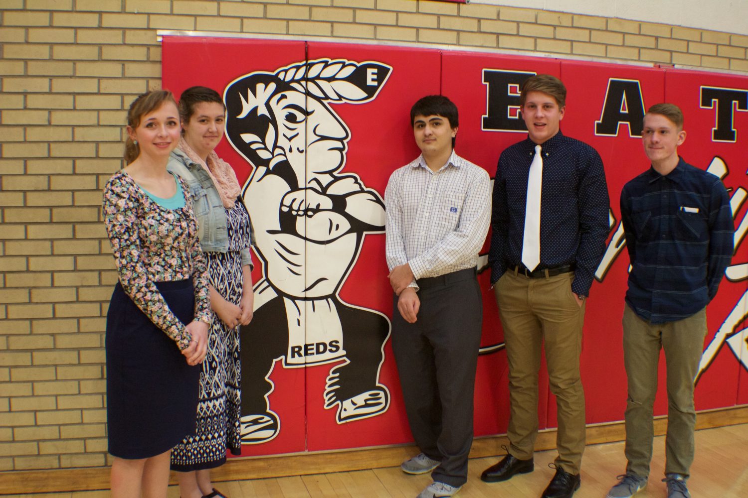 Red Ink members stand next to the mascot (left to right, Karalee Kothe(16), Sarah Jakel (17), Isaiah Cordova (17), Devan McKenney (17), and Cameron Moser (17)