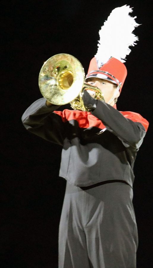 Senior marching band member, Adam Richling (18), climbs the stage and plays a mellophone solo during the song Departure.