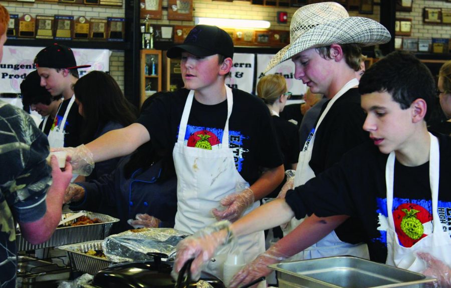 Freshmen Michael Prather, Orin Brown, Wyatte Hall, and Justin Ziegler join sophomore Gavin Huckaby in serving up community members at Taste of Eaton before the Homecoming Game.