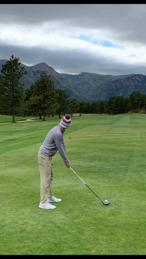 Walker Scott (20) tees with mountains in the distance
