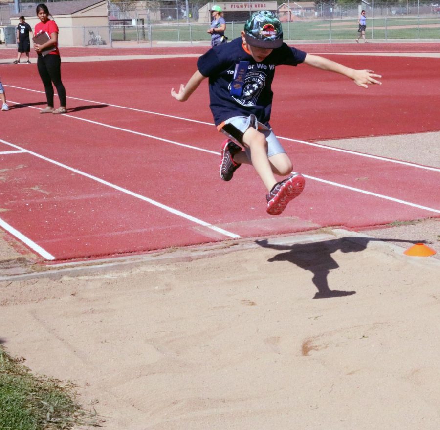 Participant jumps into the sandpit for the running long jump