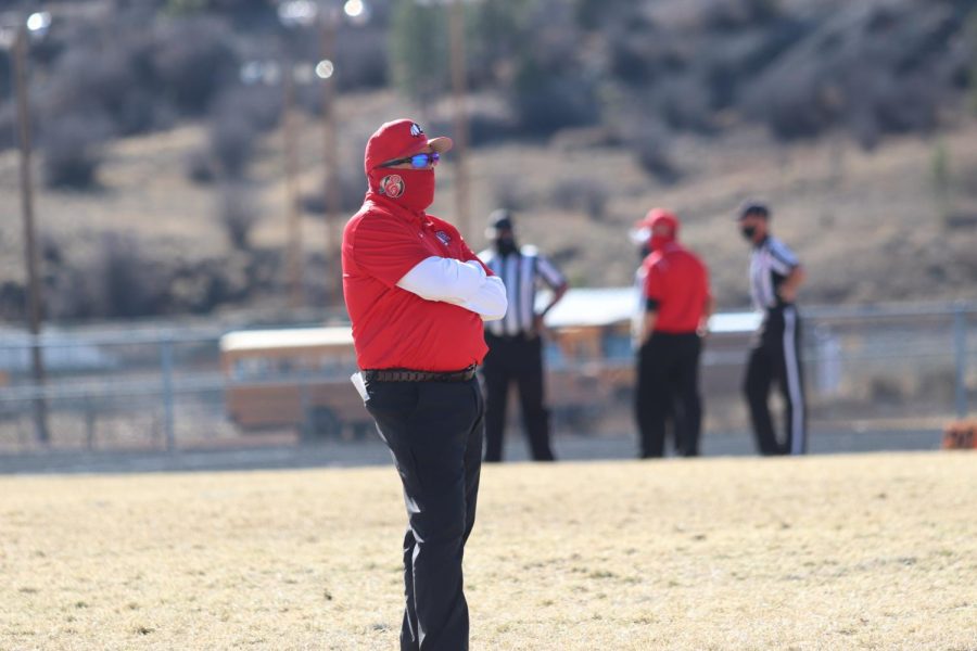 Coach Adams standing on the field before the away playoff game against Pagosa Springs in 2020