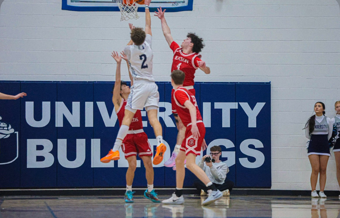 Messinger and his teammates playing a very close game and blocking their opponent from making a basket
